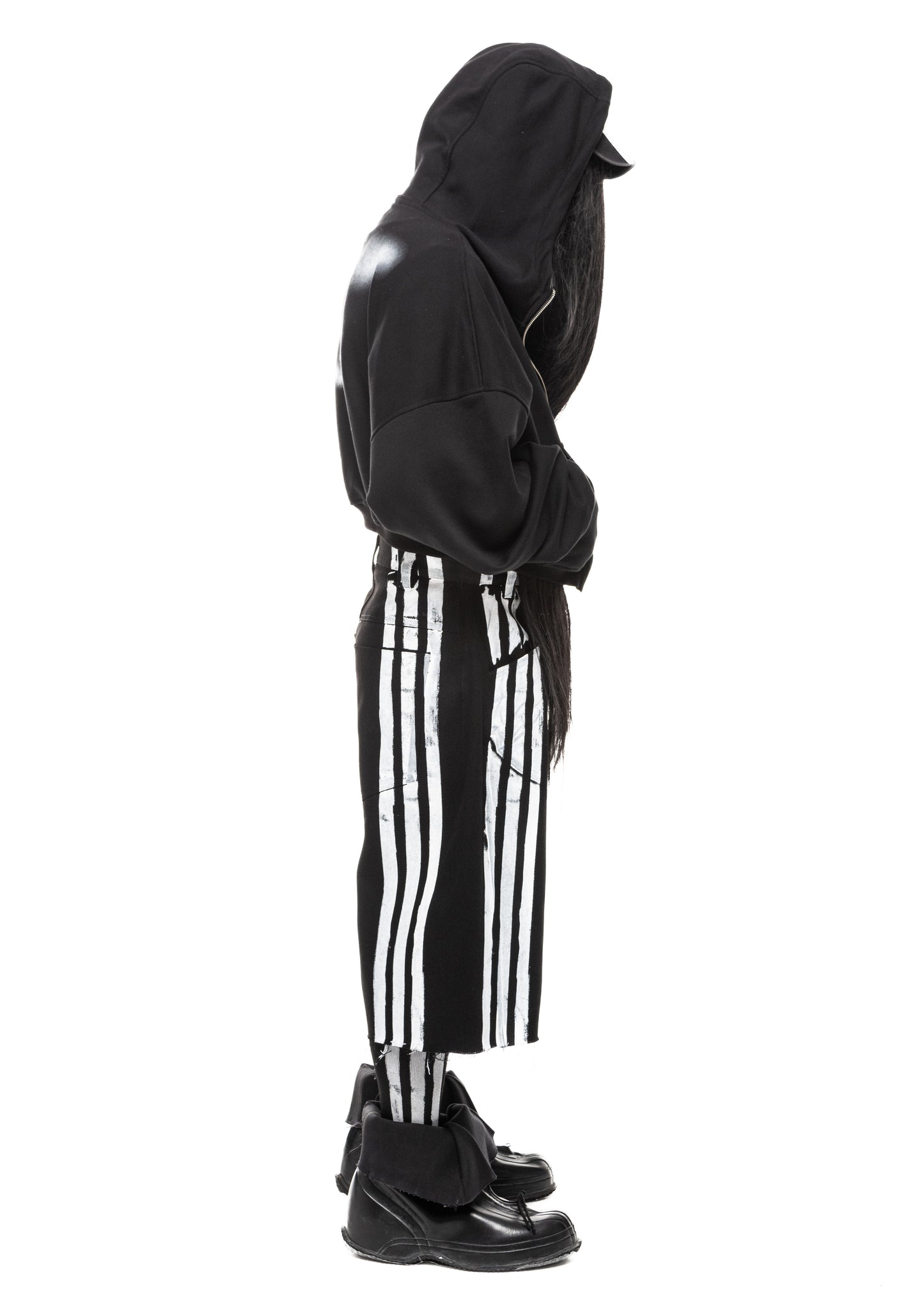Side profile of black denim shorts with printed white stripes and distressed finish