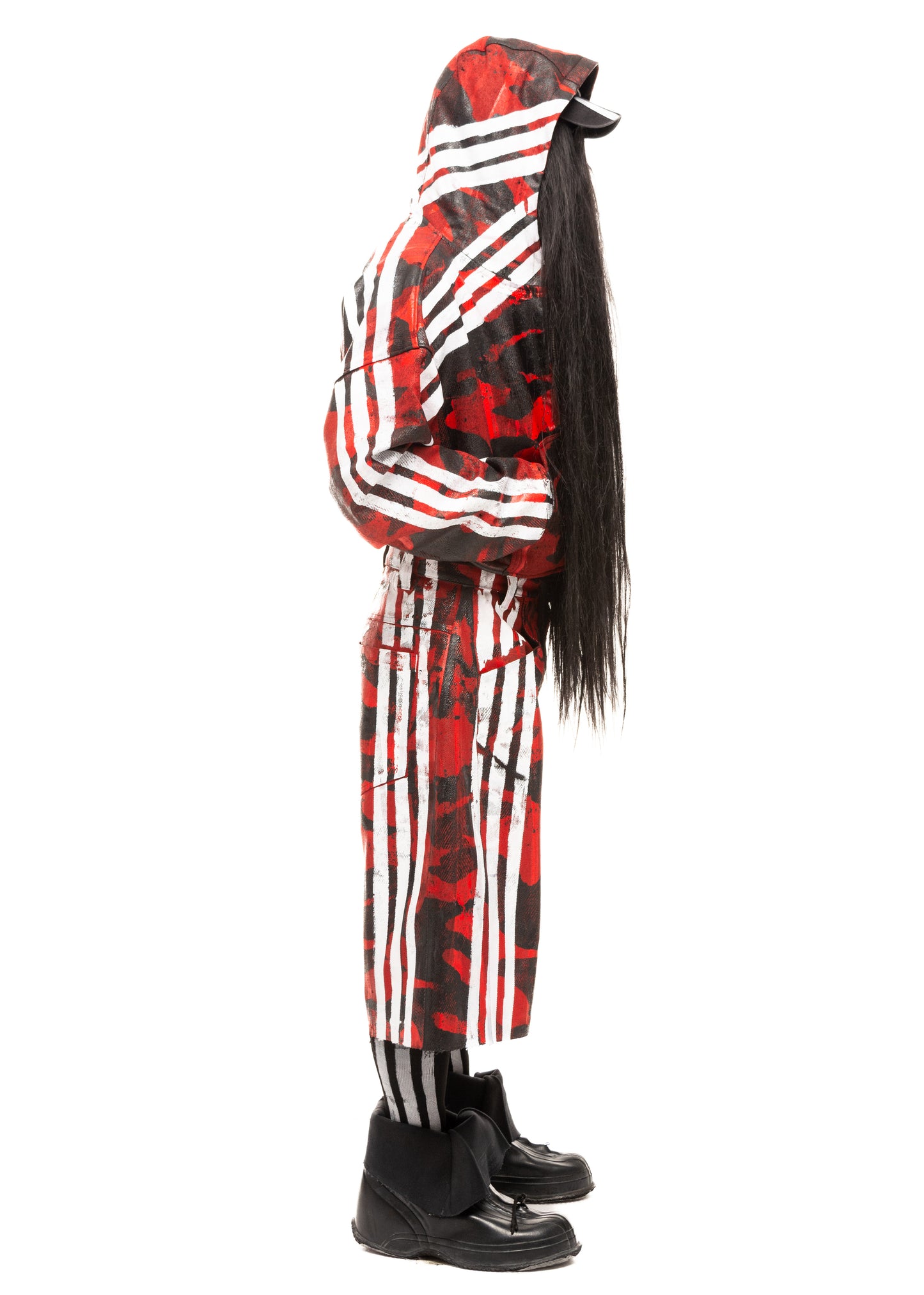 Side profile of red denim shorts with camo print and contrasting white stripes, styled with long socks and statement footwear.