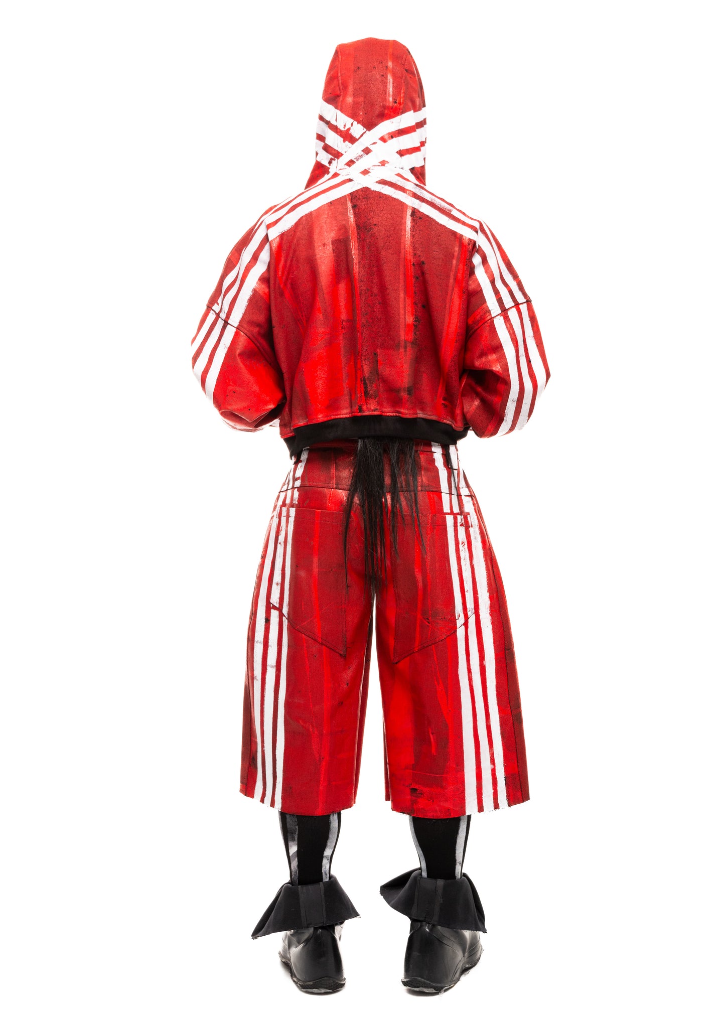 Model showing the back of red denim shorts with bold white stripes.