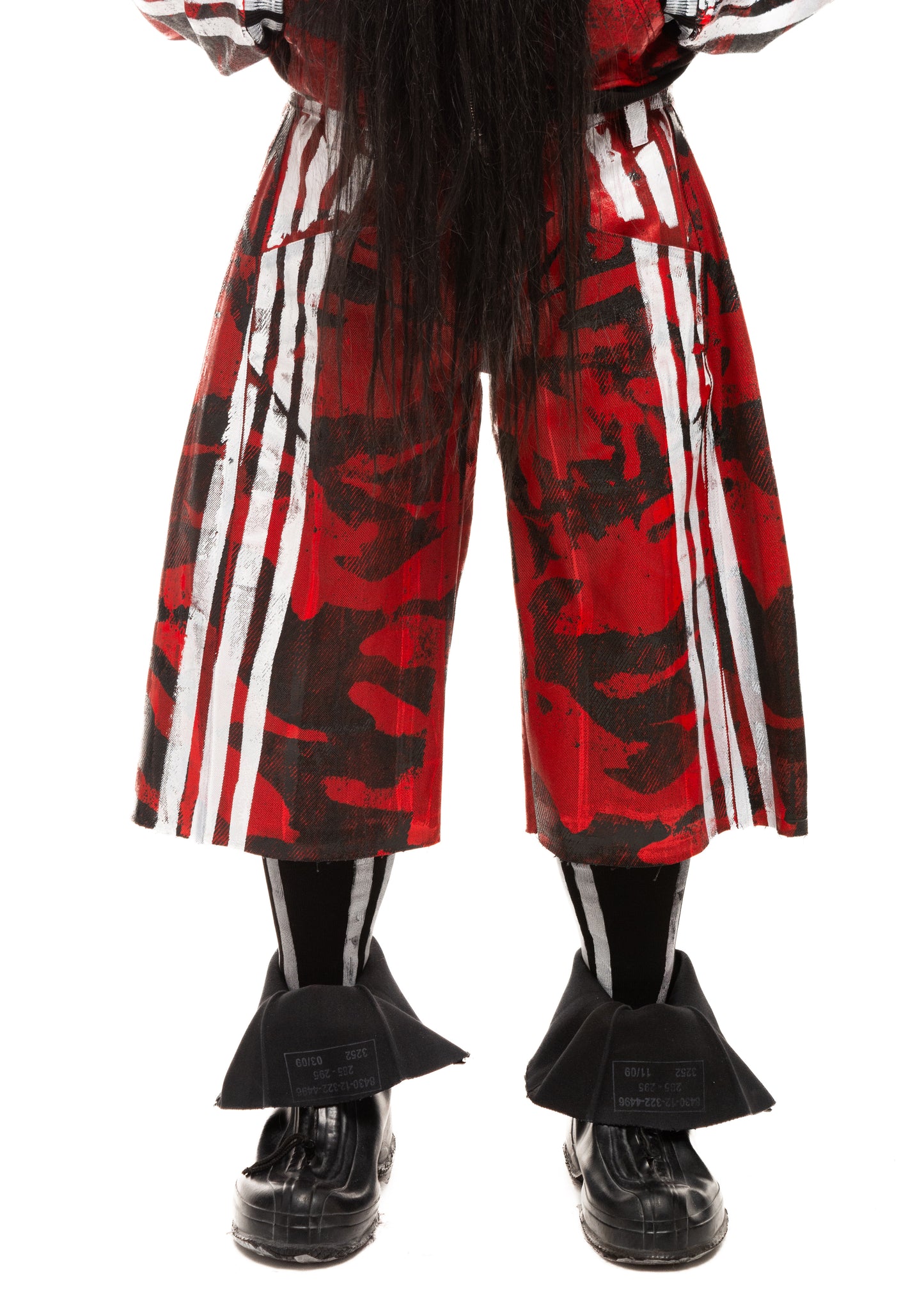 Close-up of camo waxed red denim shorts with white stripe prints, front view.