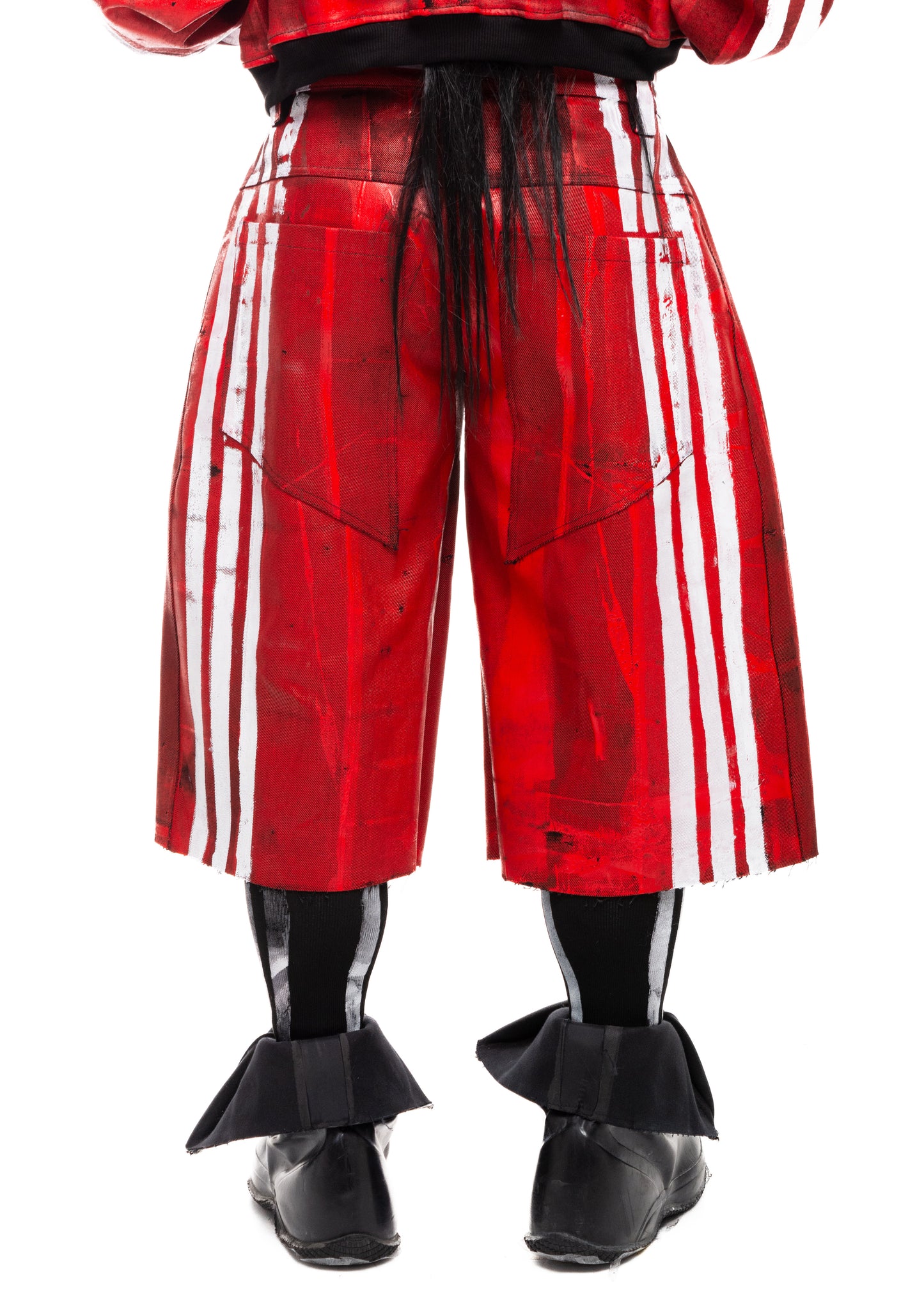 Close-up of back pockets and white stripes on red denim shorts.