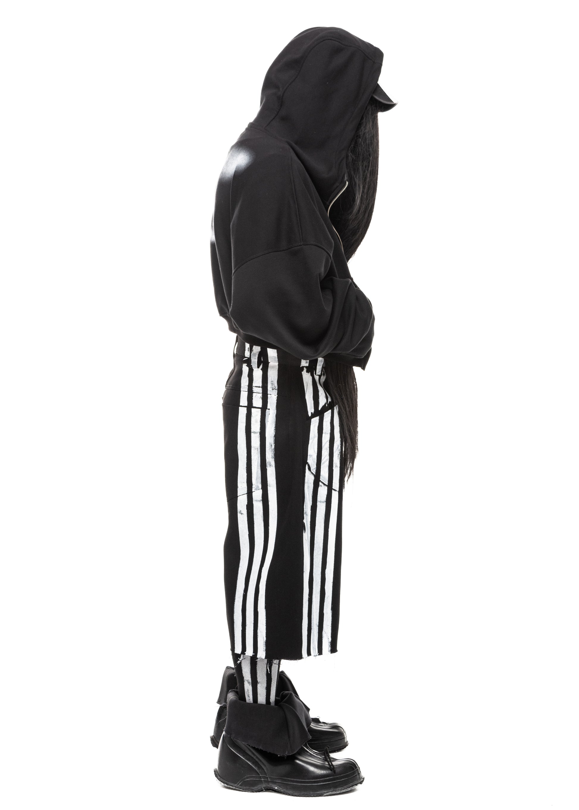 Side profile of black denim shorts with printed white stripes and distressed finish