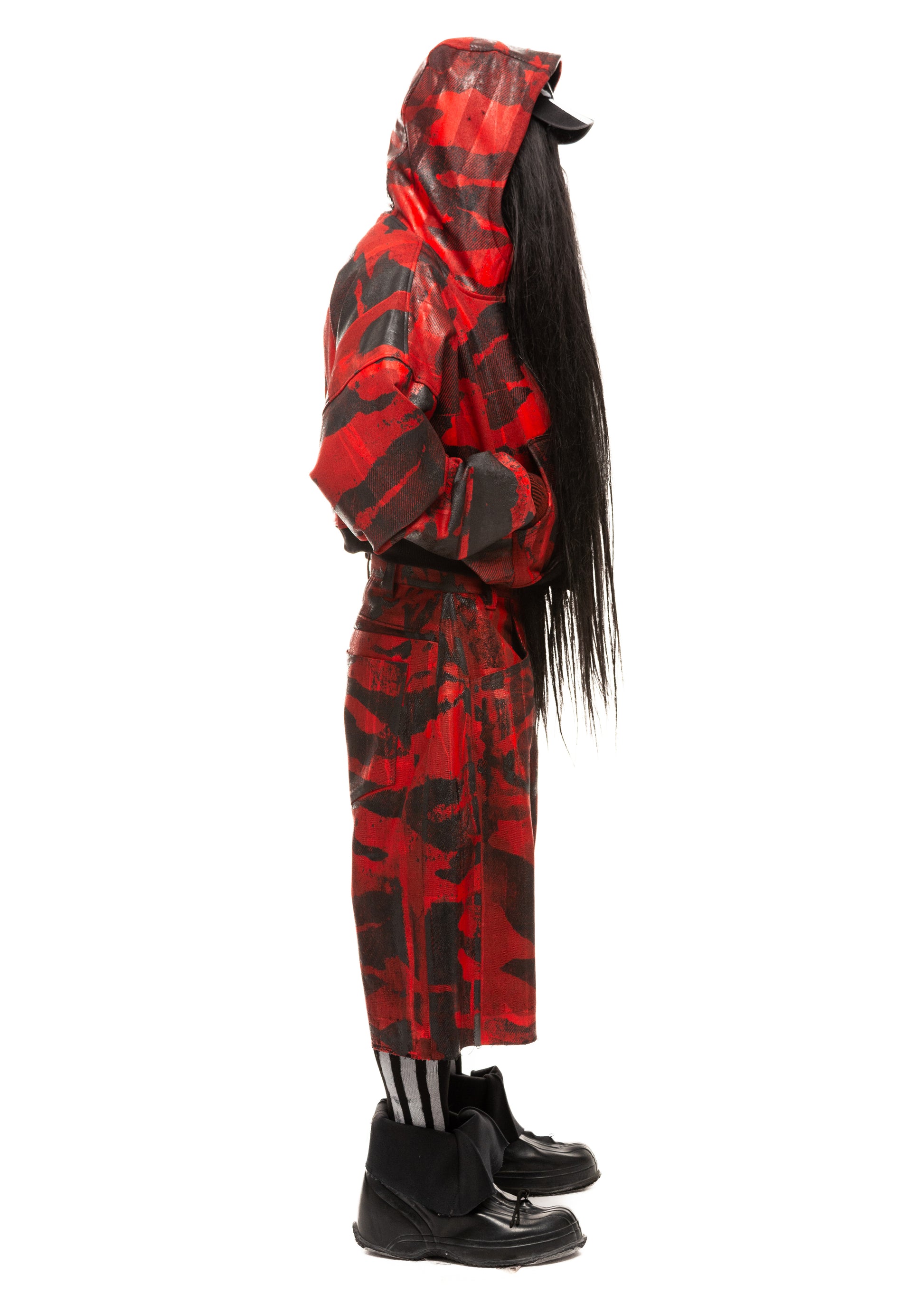 Side profile full-length view of red denim camo shorts worn with layered look