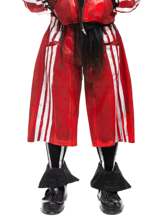 Detailed front view of red waxed denim shorts with white painted stripes.